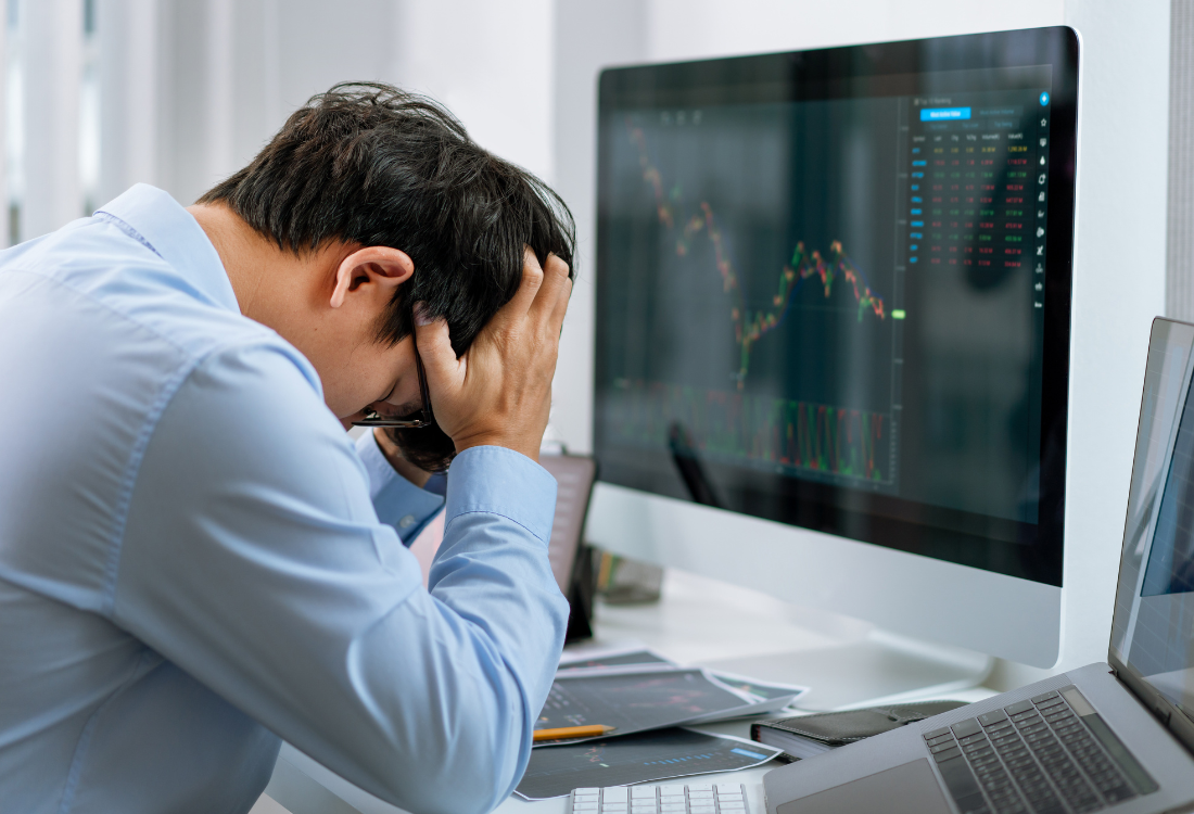 A business owner with his head in his hands facing economic stress. 