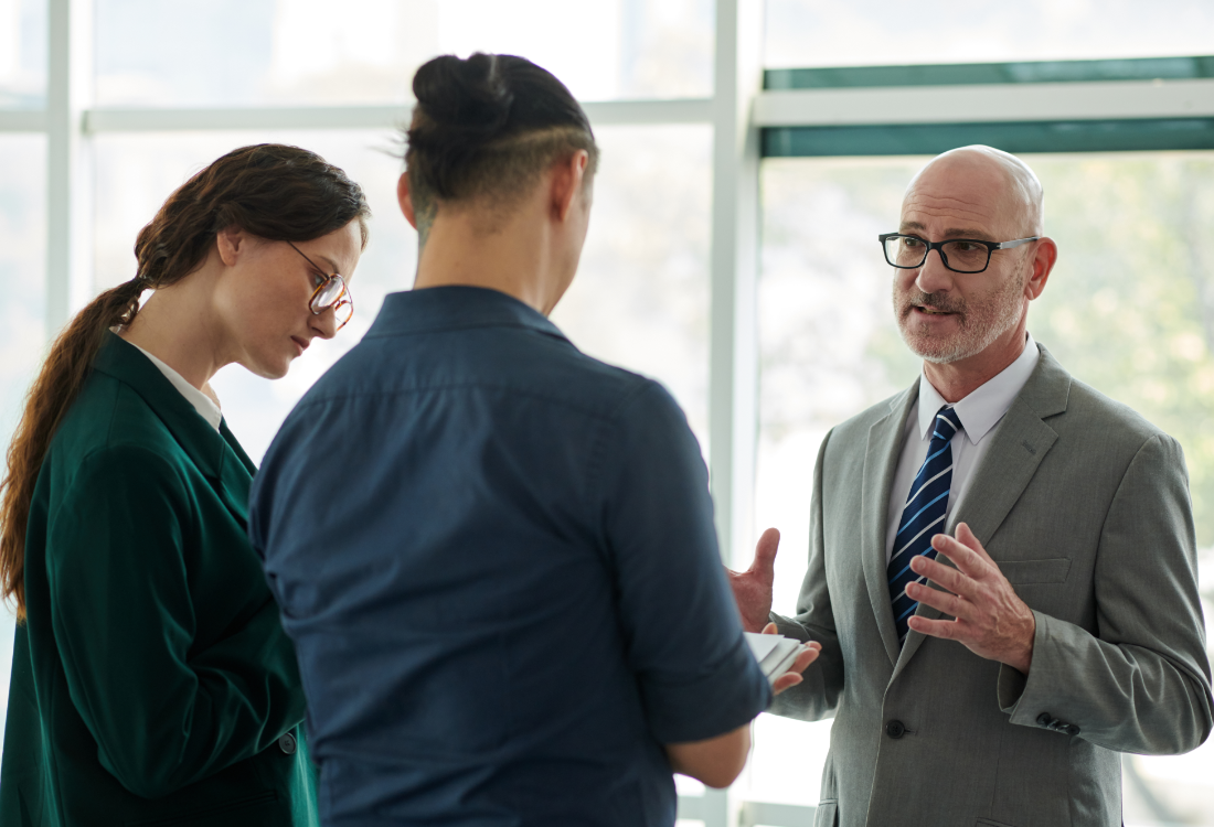 University finance leaders discussing financial planning and forecasting in a modern office setting.