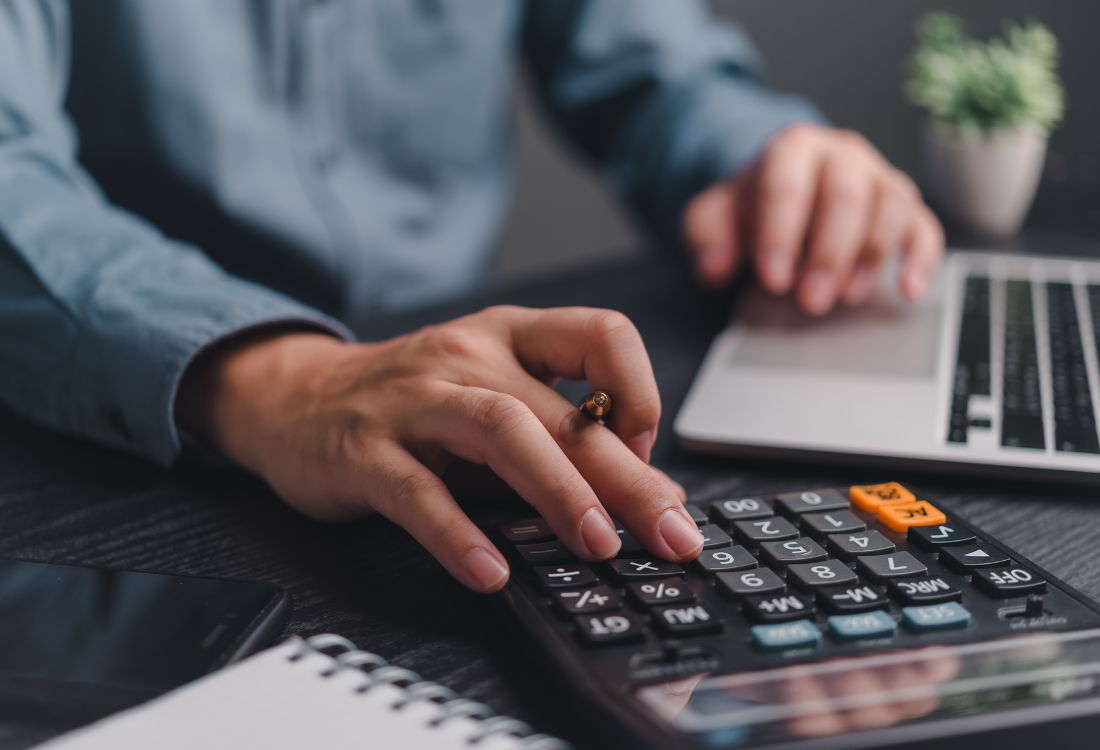 Someone using a calculator to do their budgeting prior to using 'Corporate Planner' for their budgeting and forecasting.