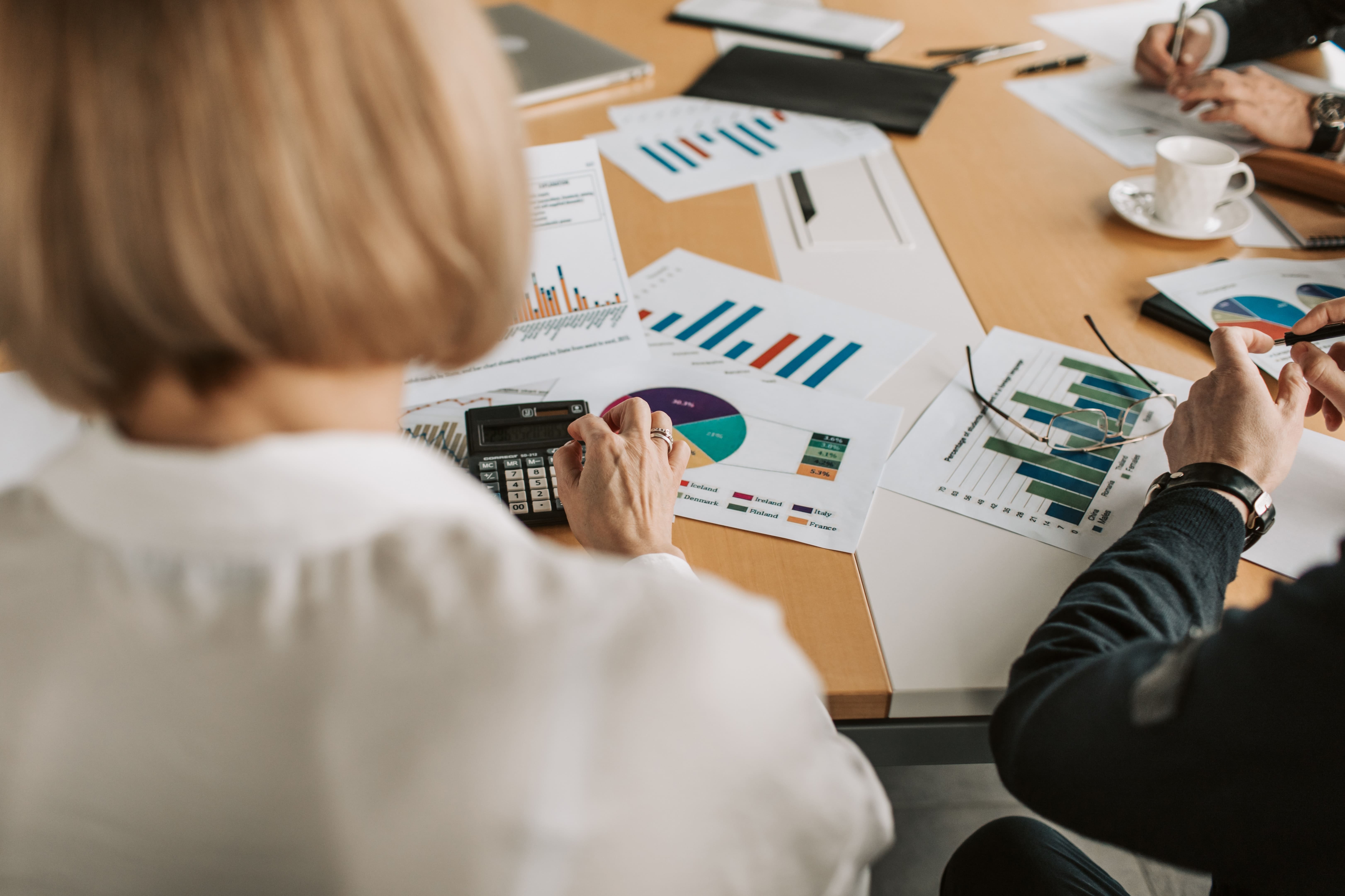 Colleagues using data and calculators to overcome challenges in Financial Reporting.